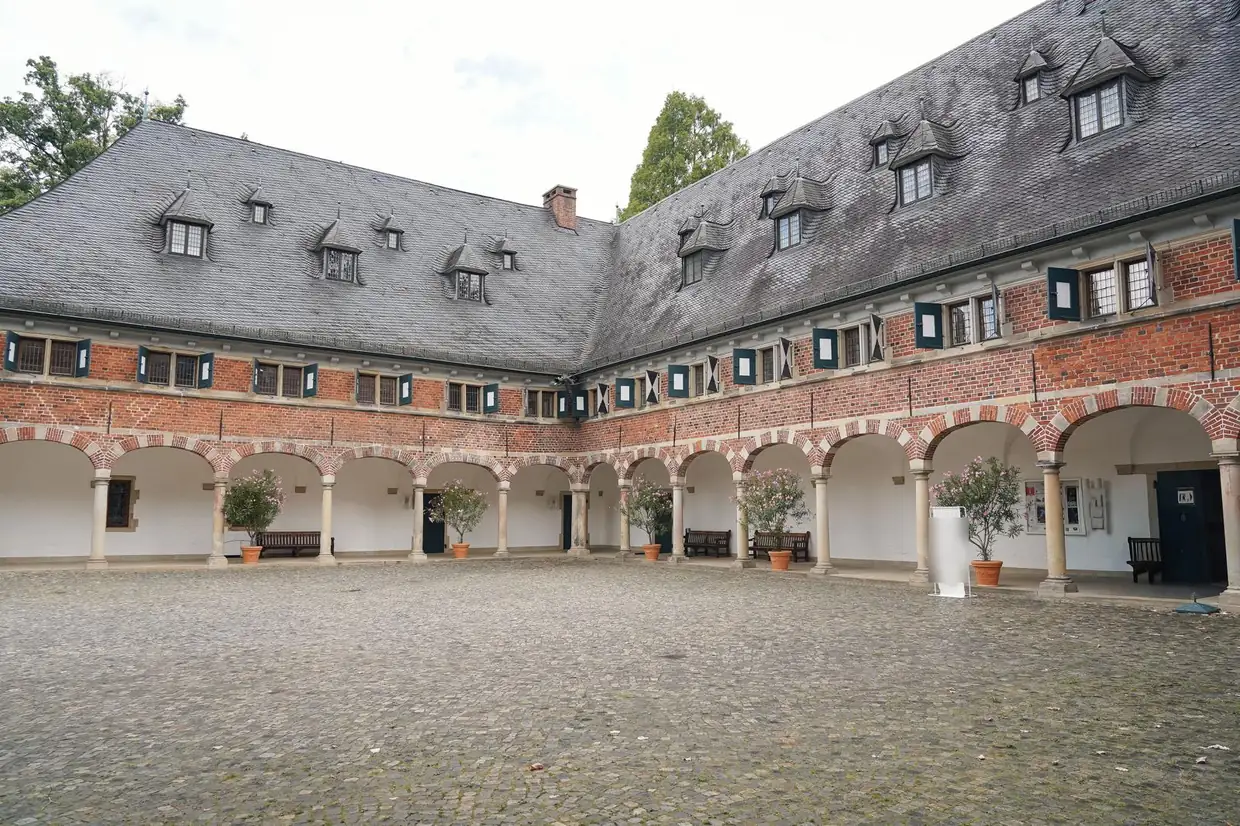 Arkaden und Kopfsteinpflaster im Innenhof von Schloss Reinbek