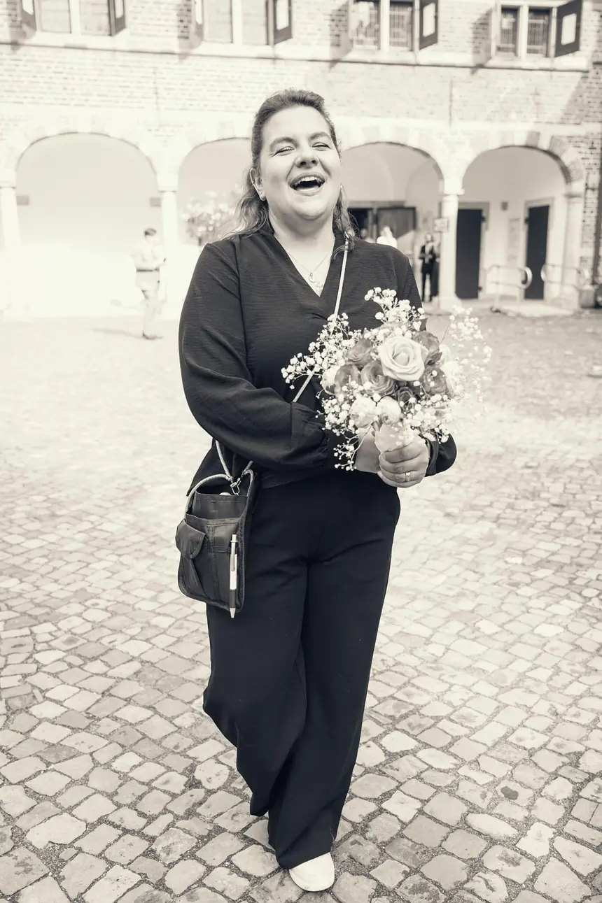 Hochzeitsplanerin mit Brautstrauß im Innenhof von Schloss Reinbek